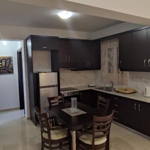 kuchnia ze stołem i krzesłami oraz kuchnia z czarnymi szafkami w obiekcie Diamond Deluxe Apartments Mastichari w Mastichárionie
