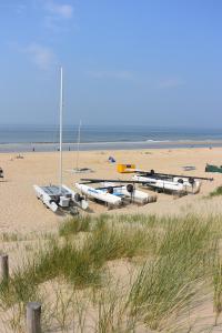 a group of boats sitting on a sandy beach at Strandhotel Golfzang in Egmond aan Zee