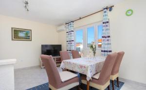 ein Esszimmer mit einem Tisch, Stühlen und einem TV in der Unterkunft Katja Apartment in Trogir