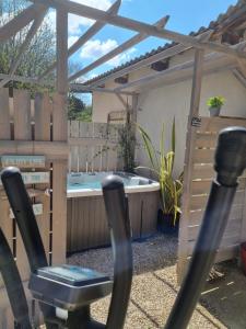 een achtertuin met een hot tub en een fitnessruimte bij Matin de Saône in Fontaines-Saint-Martin