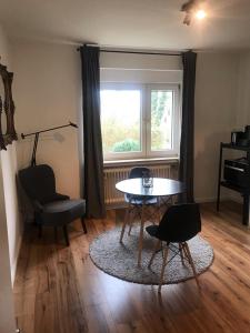 salon ze stołem i krzesłami oraz oknem w obiekcie Apartment Stockholm, top renoviert, 35qm, Köln nah w mieście Bergisch Gladbach