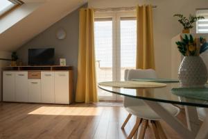 a dining room with a table and a television at Eliza 1 Birdland Golf Apartman in Bük