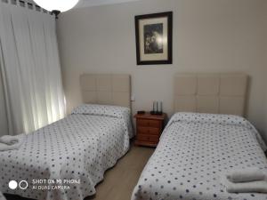 sypialnia z 2 łóżkami i zdjęciem na ścianie w obiekcie La Casa Del Rio w mieście Setenil