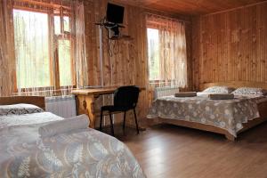 a bedroom with two beds and a desk and windows at Три Брати in Grebenov +91 photos