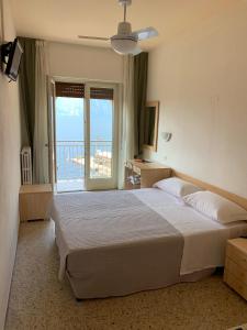 a bedroom with a large bed and a balcony at Hotel Sorriso in Brenzone sul Garda