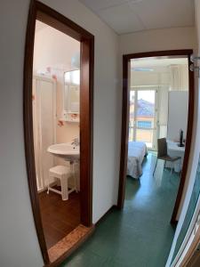 a mirror in a room with a bedroom and a bed at Hotel Sorriso in Brenzone sul Garda
