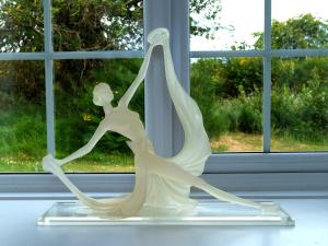 een wit standbeeld van een vrouw die voor een raam danst bij Lower Bruntlands in Fochabers