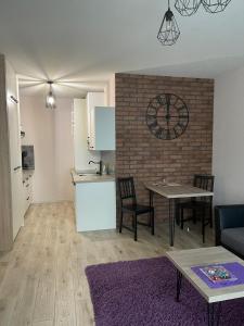 a kitchen and a living room with a table and chairs at Apartamenty Bartnicza C in Bielsko-Biała