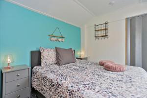 een slaapkamer met een bed en een blauwe muur bij Appartement Scheepswerf in Burgh Haamstede