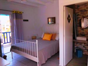 a bedroom with a bed and a balcony at Salty Kisses and Sandy Toes in Firopótamos