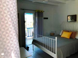 a bedroom with a bed and a balcony at Salty Kisses and Sandy Toes in Firopótamos
