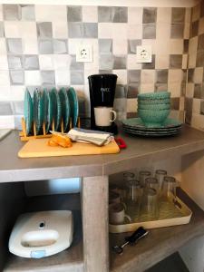 a counter with plates and bowls on a shelf at Salty Kisses and Sandy Toes in Firopótamos