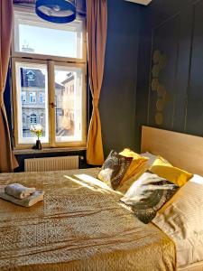 a bedroom with a bed with pillows and a window at Kazimierz Residence Square in Krakow