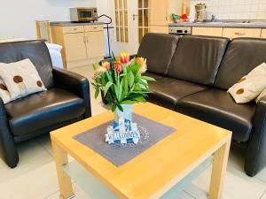 ein Wohnzimmer mit einem Sofa und einem Tisch mit Blumen in der Unterkunft Villa Seepark - Ferienwohnung 2 in Heringsdorf