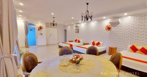 a hotel room with two beds and a table and chairs at Bai Truoc Hotel in Vung Tau