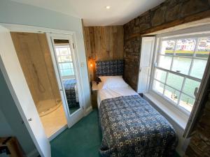 a small bedroom with a bed and a window at Harbourmaster Hotel in Aberaeron