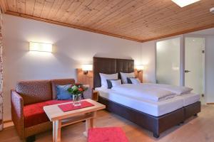 a hotel room with a bed and a couch at Hotel Helmer in Schwangau