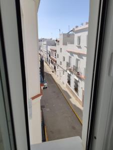 una ventana con vistas a la calle en Apartamento Conil Zona tranquila con fácil aparcamiento en Conil de la Frontera