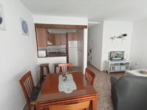cocina y comedor con mesa y sillas en Apartamento Conil Zona tranquila con fácil aparcamiento en Conil de la Frontera