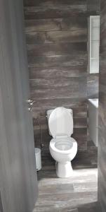 a bathroom with a toilet and a wooden wall at Studio Anastasia in Limassol