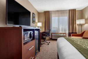 a hotel room with a bed and a flat screen tv at Comfort Inn Grand Island North in Grand Island