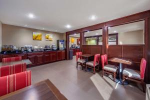 a restaurant with red chairs and a table and a counter at Comfort Inn Grand Island North in Grand Island