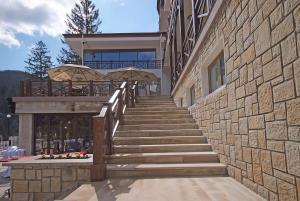 una escalera que conduce a un edificio con una pared de piedra en COMPLEX PANORAMIC en Slănic-Moldova