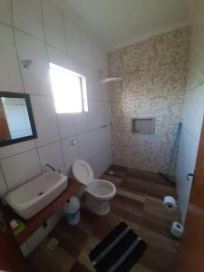 a bathroom with a toilet and a tub and a sink at Pousada Xodó in São Pedro