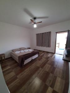1 dormitorio con 1 cama y ventilador de techo en Pousada Xodó en São Pedro