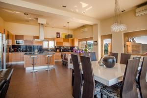 een keuken met een tafel, wat stoelen en een aanrecht bij Luxury 6-Bedroom Villa With Private Pool- Villa Prigipessa in Chania