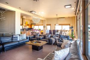 een grote woonkamer met leren banken en een tafel bij Luxury 6-Bedroom Villa With Private Pool- Villa Prigipessa in Chania