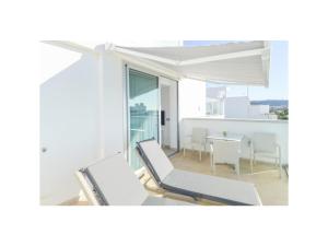 Habitación con sillas blancas y mesa con vistas. en SUNNY DAY Deluxe 14, en La Playa de Arguineguín