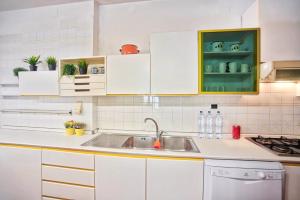 - une cuisine avec des placards blancs et un évier dans l'établissement Casa Garibaldi, à San Vincenzo