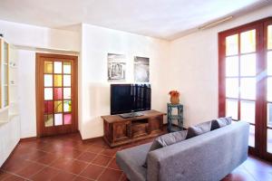 een woonkamer met een bank en een flatscreen-tv bij Casa Garibaldi in San Vincenzo