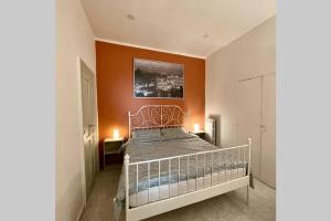 a bedroom with a bed with an orange wall at PetinoInApulia - Appartamento per famiglie e amici in Bari