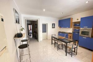 a kitchen with blue cabinets and a table and chairs at PetinoInApulia - Appartamento per famiglie e amici in Bari