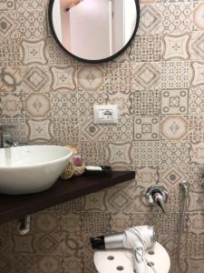uma casa de banho com um lavatório e um espelho na parede em b&b nonno peppe em Palermo