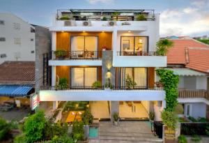 an apartment building with a balcony with plants at Tam Hong Phuc Homestay Hoi An in Hoi An