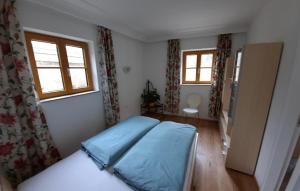 a bedroom with a bed and two windows at Ferienhaus und Apartment Idolsberg in Idolsberg