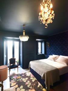um quarto com uma cama grande e um lustre em toctoctoc lisboa em Lisboa