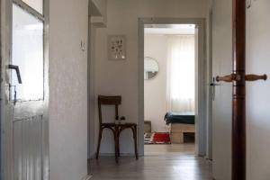 pasillo con silla y puerta a una habitación en JELA Countryside House, en Kosjeric