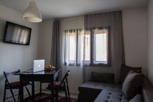 a living room with a couch and a table with a laptop at JELA Countryside House in Kosjerić