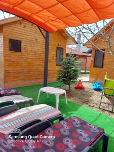 a tent with two beds and a table in a yard at La Botezatu in Tuzla