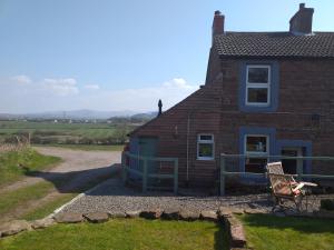 ein Haus mit einem Stuhl davor in der Unterkunft Bank End in Egremont