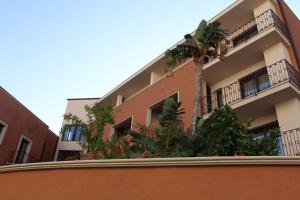 a building with a palm tree in front of it at Artemis Hotel in Cefalù