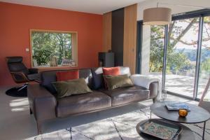 a living room with a brown couch and a table at Domaine 669, Villa contemporaine et de prestige in Alès