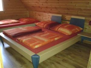 three beds in a room with wooden walls at Ranczo Pobierowo in Pobierowo