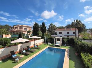 una piscina en un patio con sillas y sombrillas en Villa Colibrí, con piscina privada para 6 personas, en Santa Ponsa