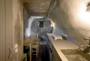 a bathroom with a sink and a counter with chairs at Alonaki Tinos Rental Cottage house in Skaládhos