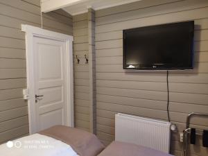 Habitación con TV en la pared y puerta en Laugar Guesthouse en Laugar